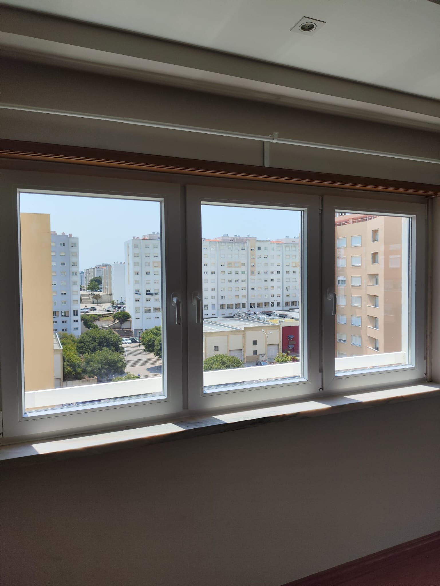 Janela tripla em PVC branco num apartamento