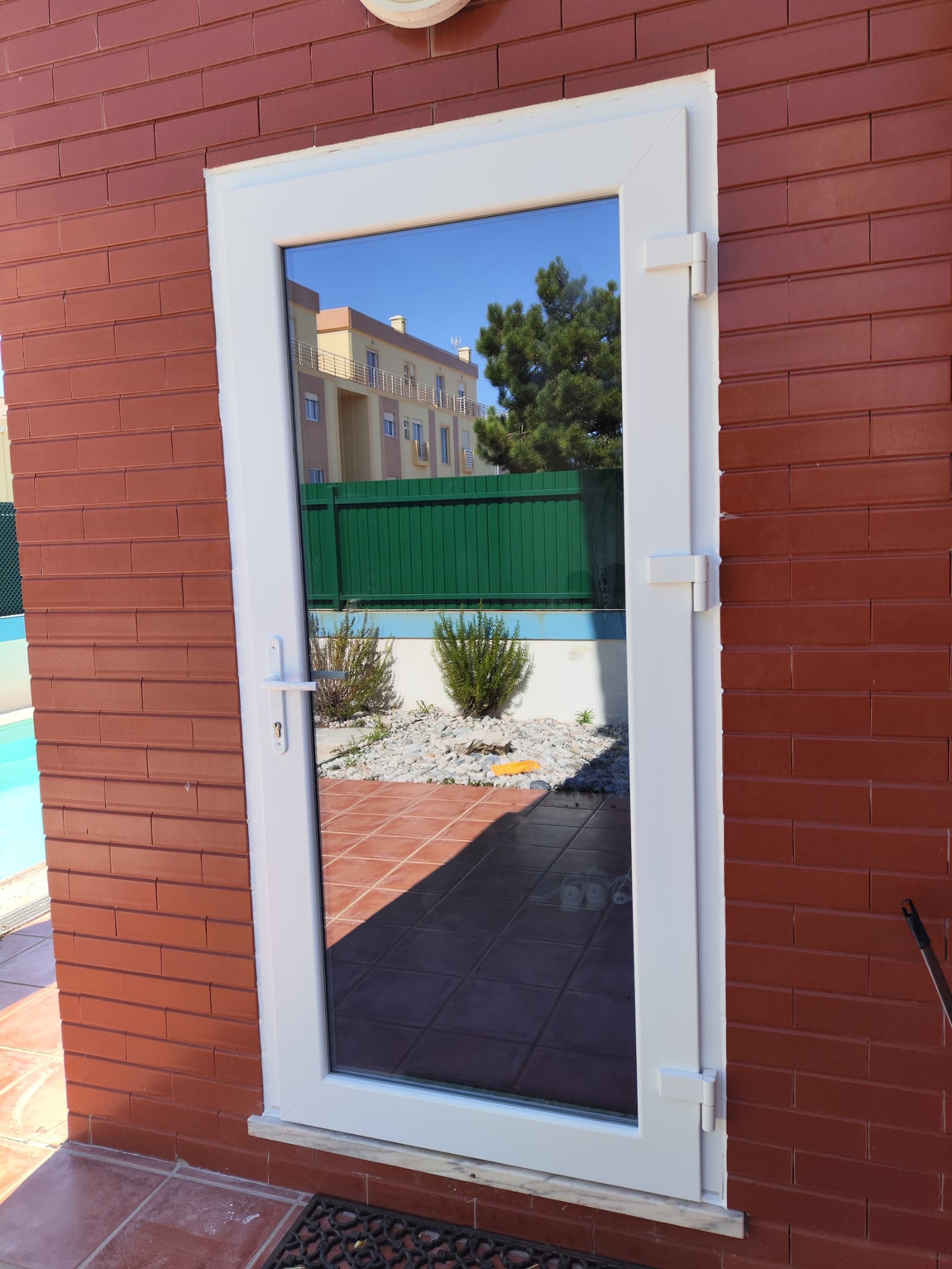Porta envidraçada em PVC numa moradia com piscina