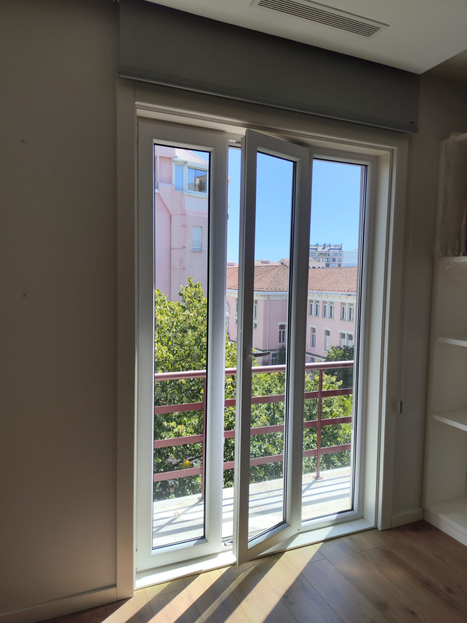 Porta de varanda em PVC aberta com vista para a cidade